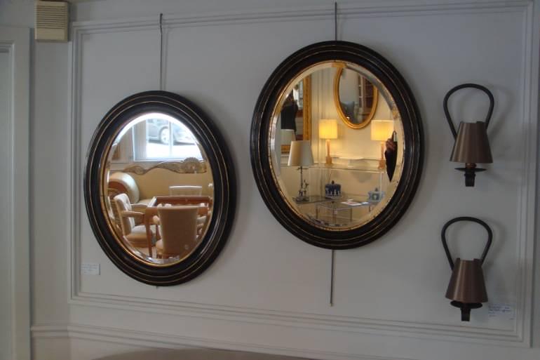 Pair of black ebonised and gold ovals with bevelled glass mirror plate, French Napoleon III c1890