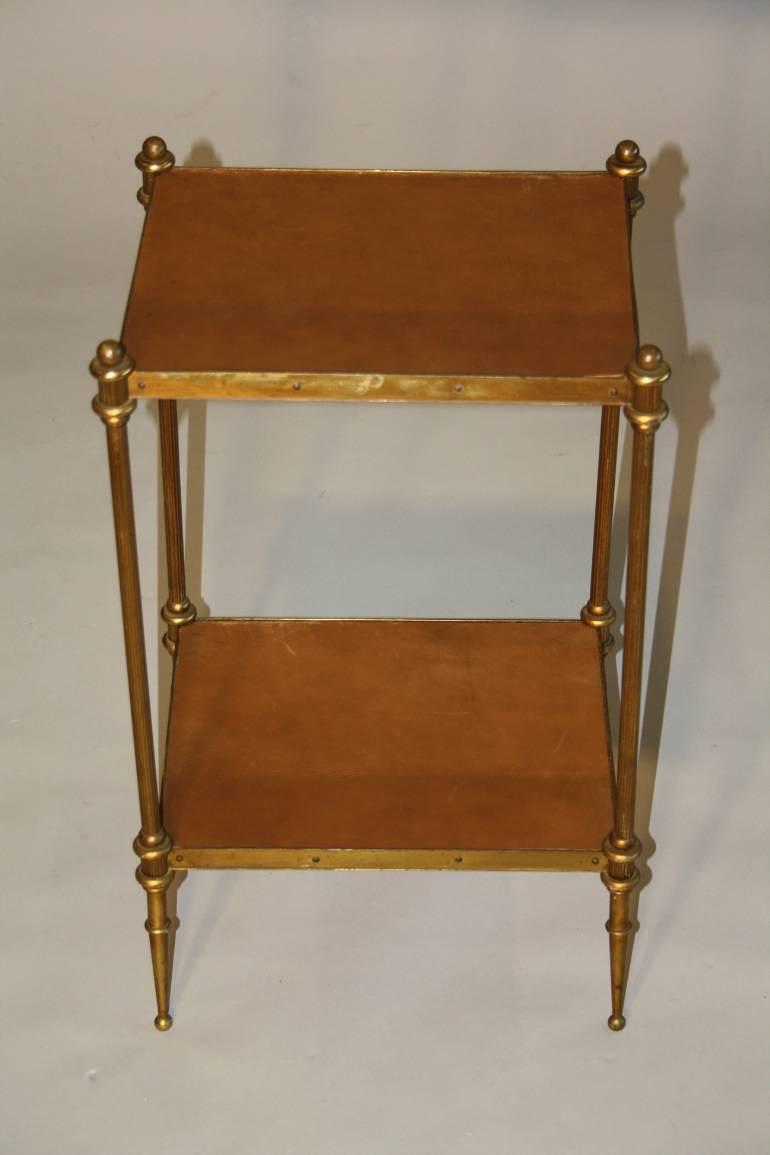 A small elegant two tier leather and brass side table. French c1950`s, stamped Hermes