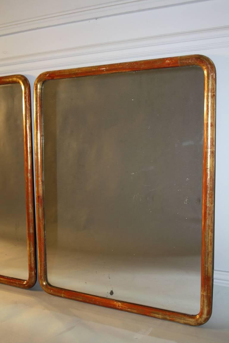 A pair of C19th narrow edge gilt framed mirrors with mercury plate.