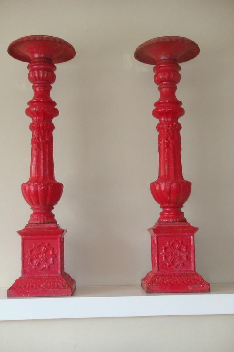 A pair of 19thC Victorian red painted cast iron candlesticks