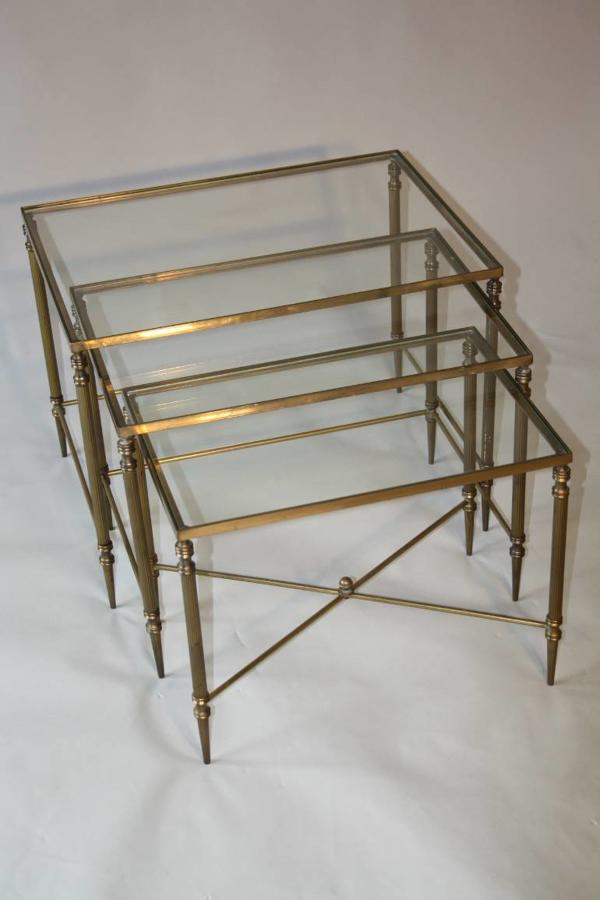 A clear glass and brass nest of tables