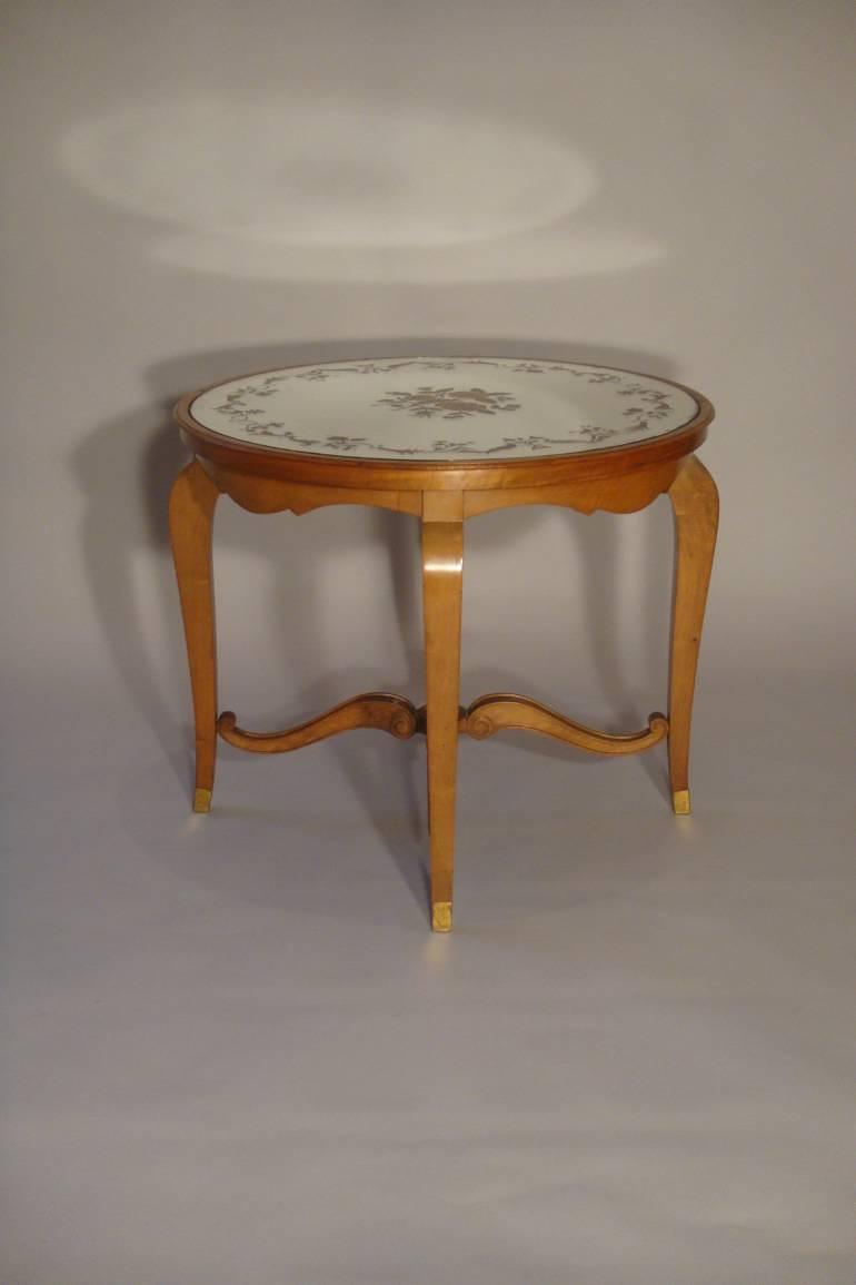 Beautiful French 1940`s carved walnut occasional table with original verre eglomise top and sabot feet.