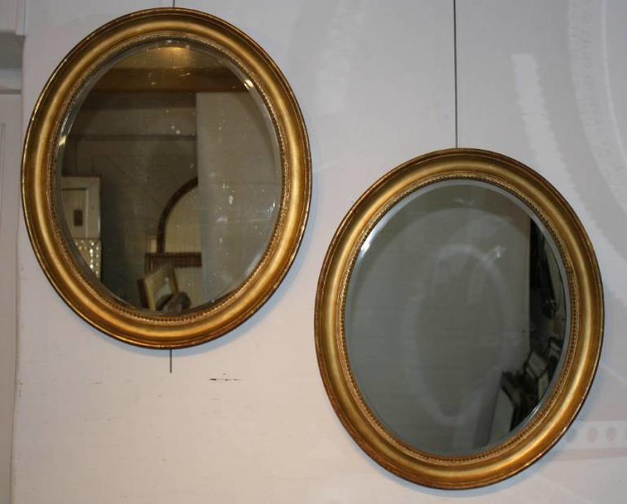 A pair of antique gold leaf oval mirrors, with bevelled glass plates, French c1850