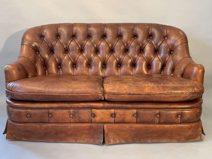 A buttoned tan leather two seat sofa