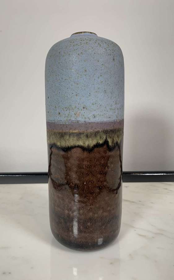 A tall cylindrical glazed vase